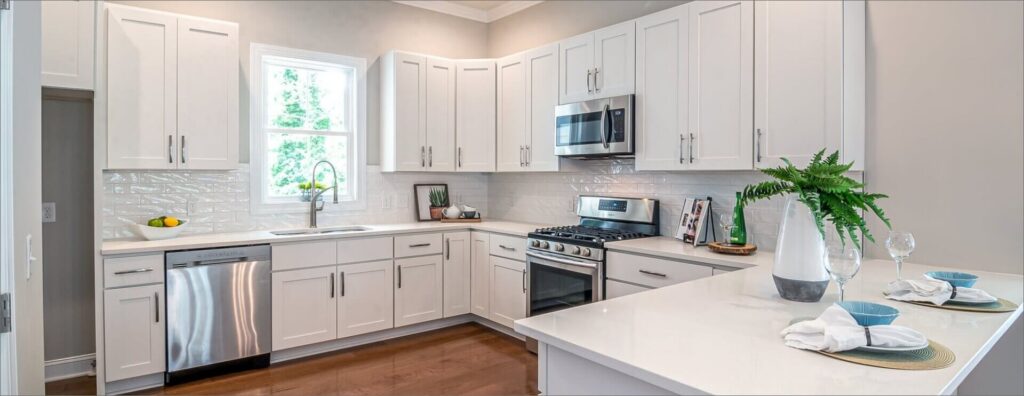 Modern kitchen with white cabinets, stainless steel appliances, and a spacious countertop, designed with a bright and clean aesthetic.