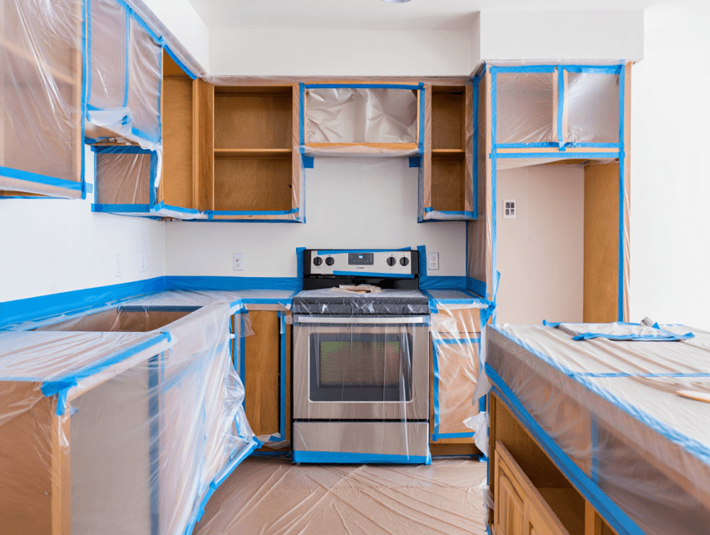 The Ultimate Guide to Restoring Wood Cabinets to Their Former Glory Right in Your Utah Home 3 A kitchen meticulously prepped for professional cabinet refinishing, with all surfaces protected to ensure a clean and organized process for the homeowner.