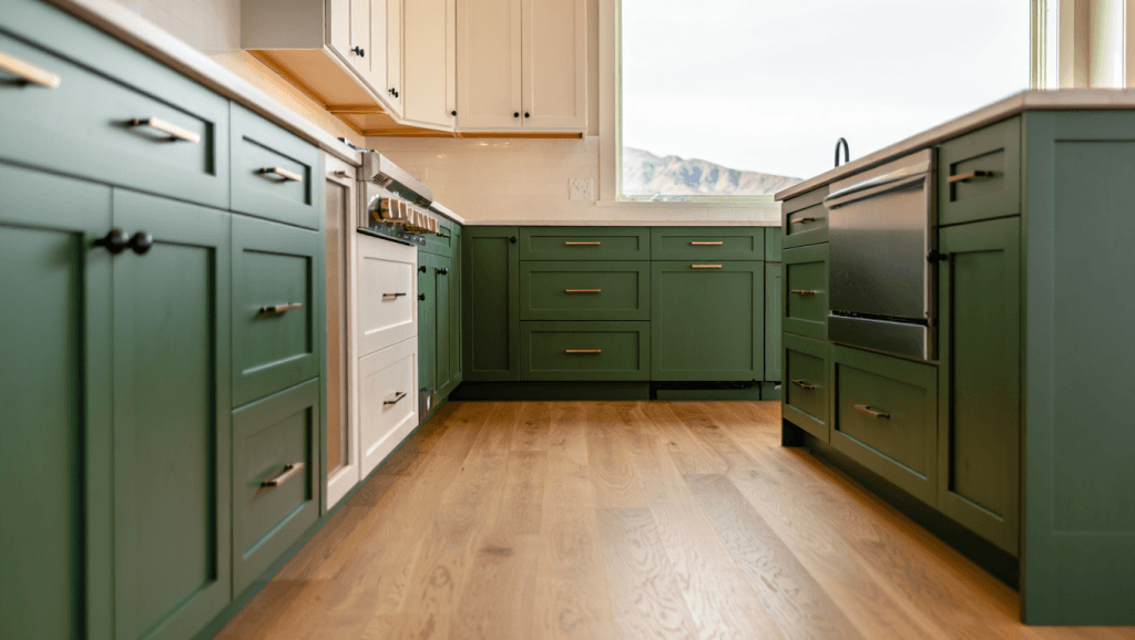 Utah kitchen with deep green cabinet paint in lower kitchen cabinets and white uppers, white oak floors, and matte black hardware