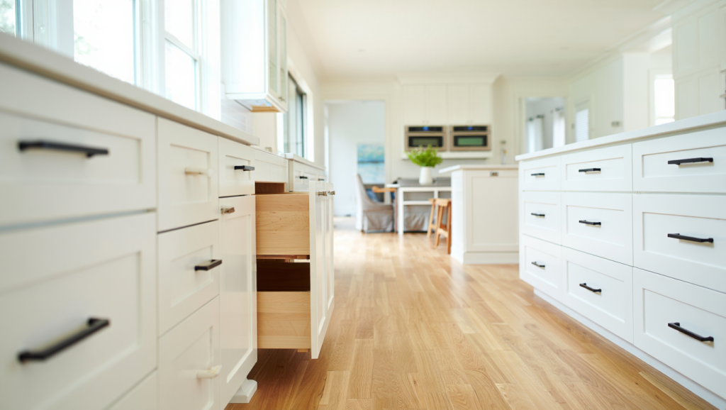 How Much Does it Cost to Paint Kitchen Cabinets in Utah? 5 Fully renovated bright white kitchen with painted cabinets, gold hardware, and hardwood floors.