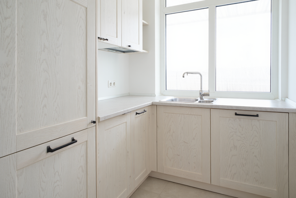 Wide shot of a Utah-style kitchen with white painted cabinets, good natural light from multiple windows, clean and crisp finish