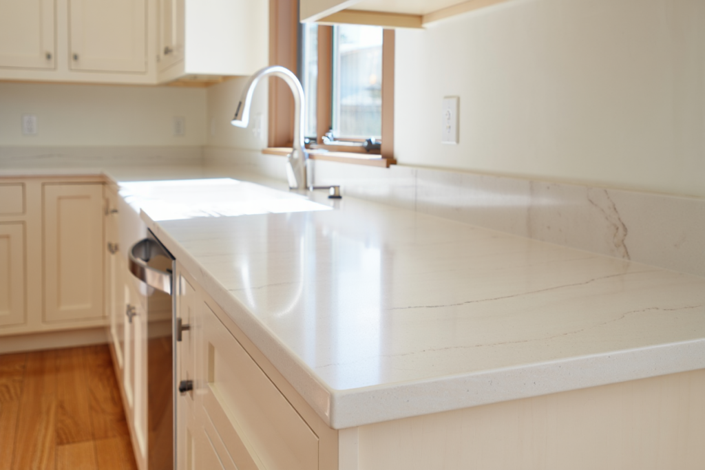 A Utah-style kitchen with warm white shaker cabinets, white quartz countertops with subtle gray veining