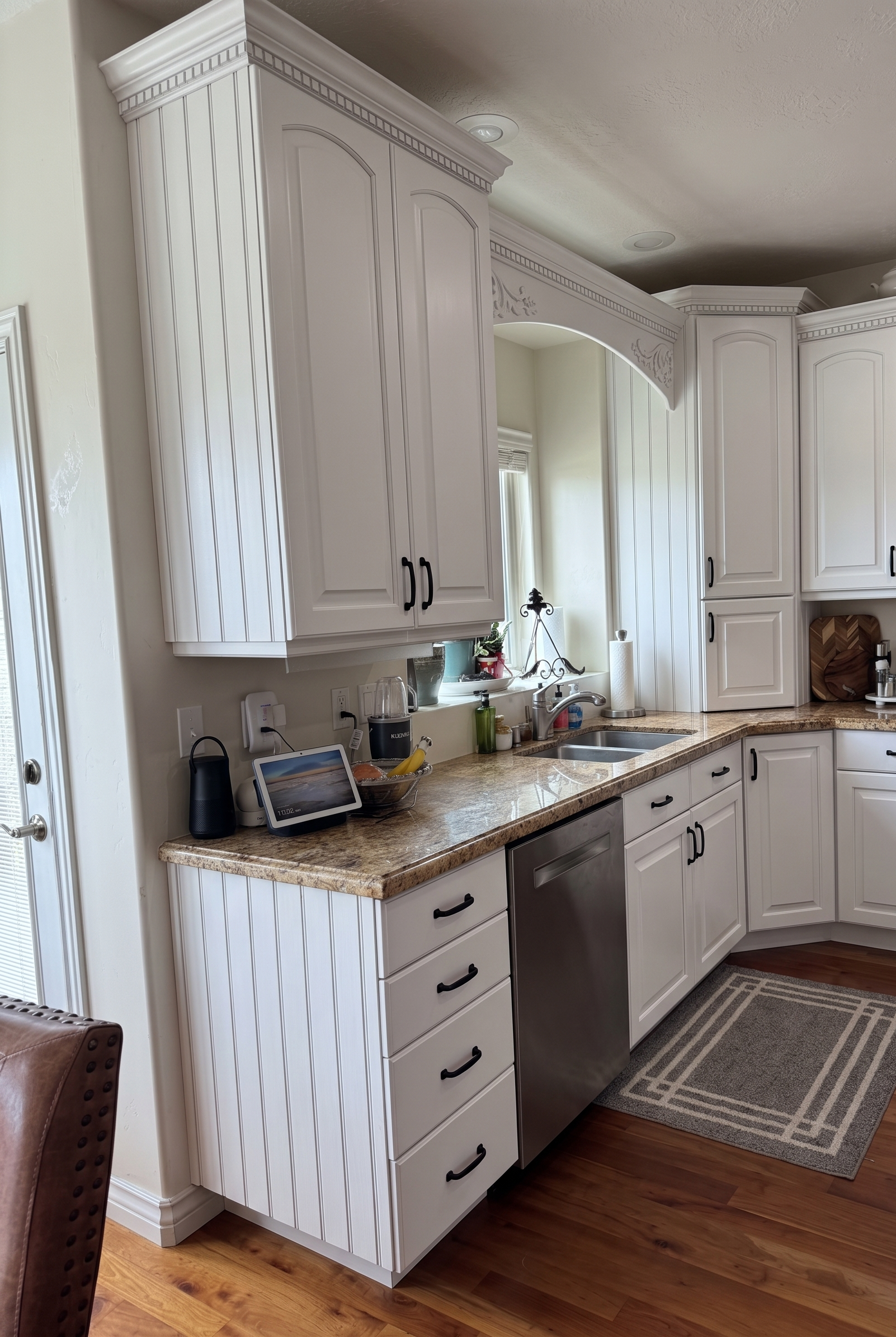 Professionally painted white kitchen cabinets in a Utah home, smooth satin finish, black hardware. What to look for when hiring a cabinet painter