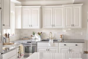 Affordable cabinets in Bluffdale shown as repainted solid wood doors in a warm white satin finish in a suburban Utah kitchen